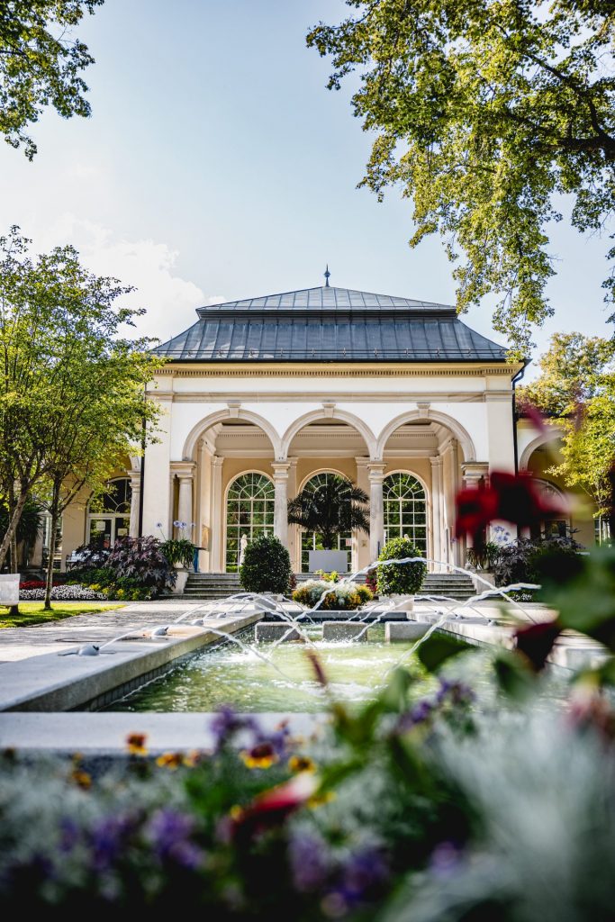 Park mit Wasser und Haus im Hintergrund.