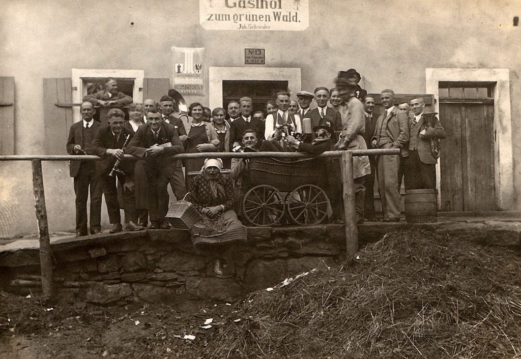 Ein Gruppenbild von Menschen, die in den 1930er Jahren Kerwa feiern und sich vor einem Wirtshaus aufgestellt haben.