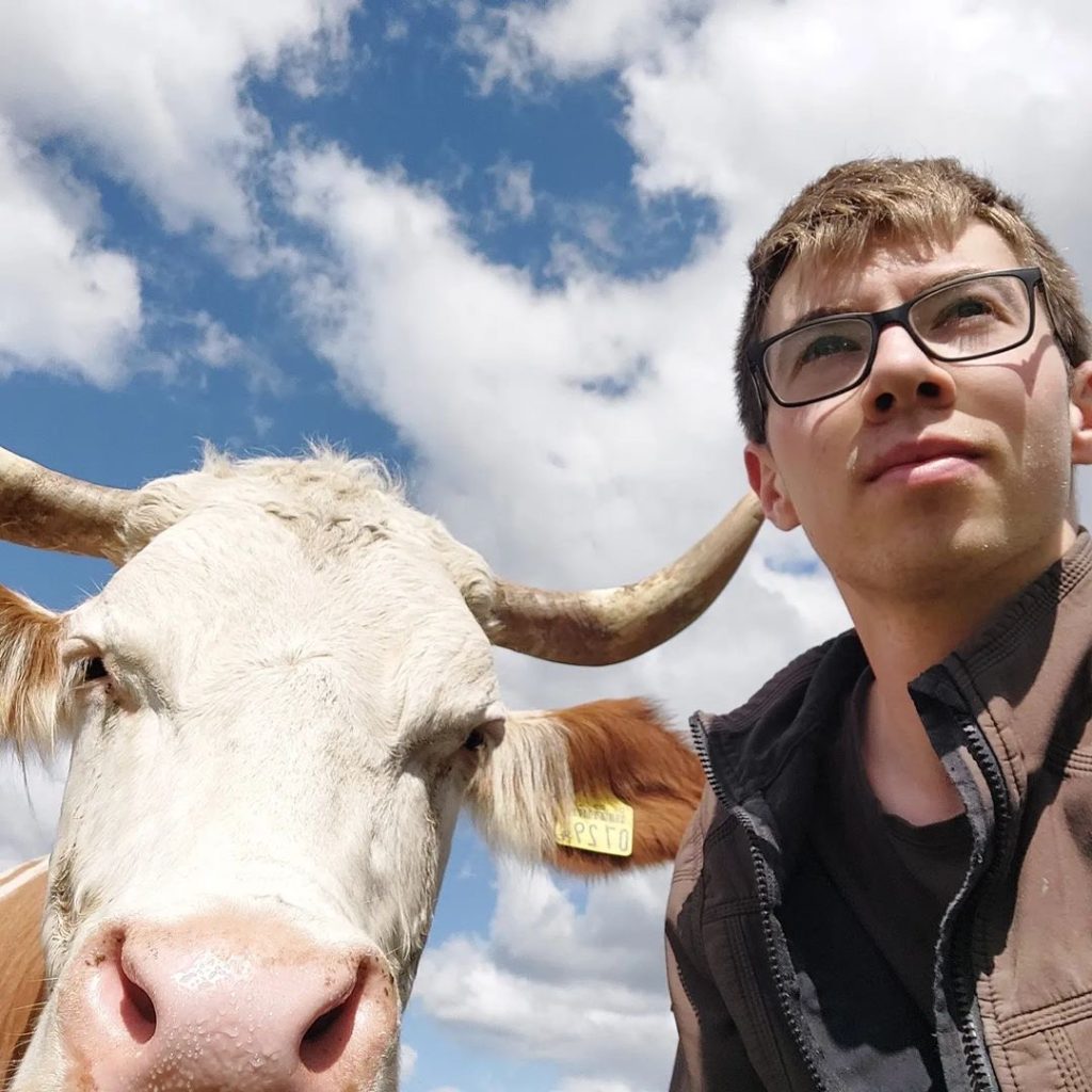 Junger Landwirt mit seiner Kuh