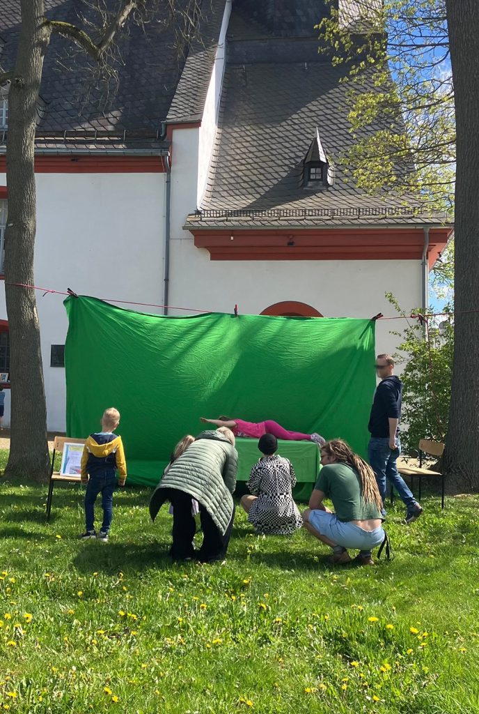 Helfer der Familienkirche spannen ein großes grünes Tuch