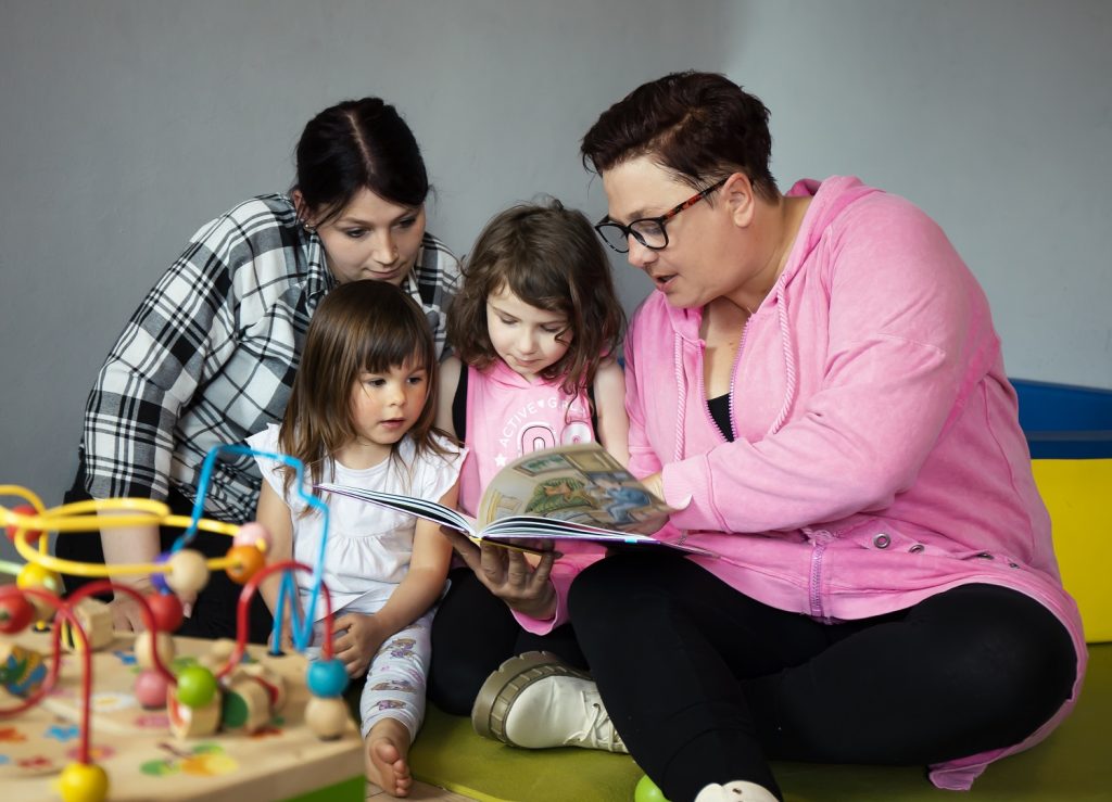 Familie mit zwei Kindern liest in einem Buch
