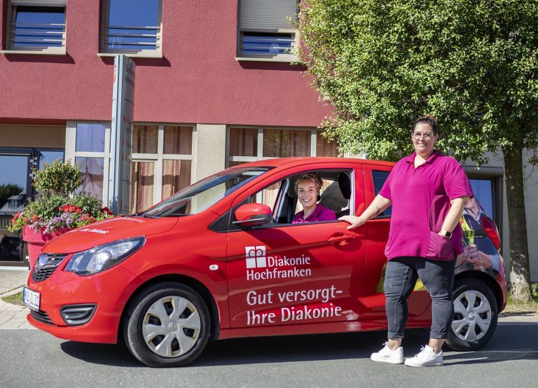 Auto der Diakonie Hochfranken mit zwei Angestellten