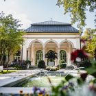 Park mit Wasser und Haus im Hintergrund.